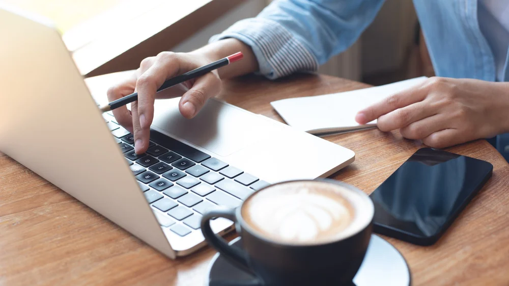Working from home with a laptop and a coffee.